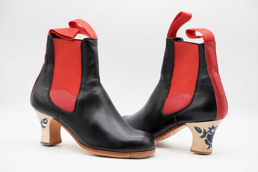Zapatos de Flamenco profesional. Modelo Bota de Mujer. nº36. Únicos, hechos a mano por Antonio García. Fabricado en pielnegro con detalles en rojo. Tacón Semicarrete con flor pintada barnizado de 6,5 cm. Con clavos. Suela profesional cosida con filis de microfibra para amortiguar el golpe. Duración y sonido excepcional. Uno de los últimos zapatos fabricados por el artesano.