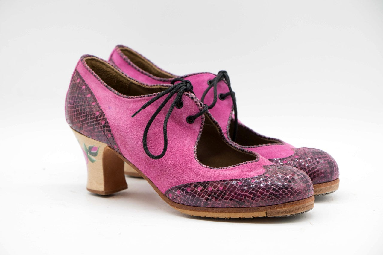 Zapatos de Flamenco profesional para mujer. Modelo Martinete, nº37. Únicos, hechos a mano por Antonio García.  Con cordones. Fabricado en Ante fucsia y con puntera y trasera en serpiente burdeos. Tacón Semicarrete con flor rosa pintada a mano Barnizado de 6,5 cm. Con clavos. Suela profesional cosida con filis de microfibra para amortiguar el golpe. Duración y sonido excepcional. Uno de los últimos zapatos fabricados por el artesano.