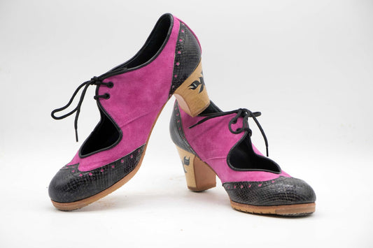 Zapatos de Flamenco profesional para mujer. Modelo Martinete, nº37. Únicos, hechos a mano por Antonio García.  Con cordones. Fabricado en Ante fucsia con puntera y trasera en serpiente negra. Tacón nº0 con flor negra pintada a mano Barnizado de 6,5 cm. Con clavos. Suela profesional cosida con filis de microfibra para amortiguar el golpe. Duración y sonido excepcional. Uno de los últimos zapatos fabricados por el artesano.