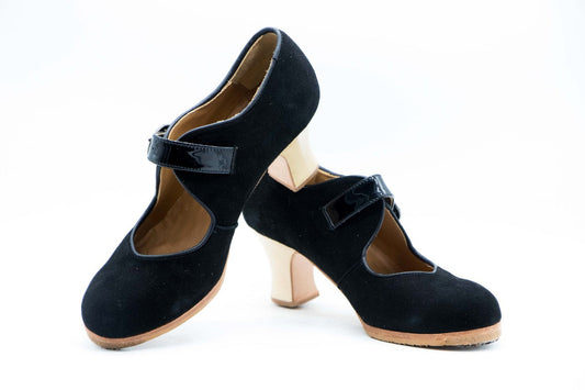 Zapatos de Flamenco profesional para mujer. Modelo Soleá, nº34,5. Únicos, hechos a mano por Antonio García. Cerrado con correa ancha. Fabricado en Ante Negro con detalles en charol negro. Con Tacón Semicarrete barnizado de 6,5 cm. de altura. Con clavos. Suela profesional cosida con filis de microfibra para amortiguar el golpe. Duración y sonido excepcional. Uno de los últimos zapatos fabricados por el artesano