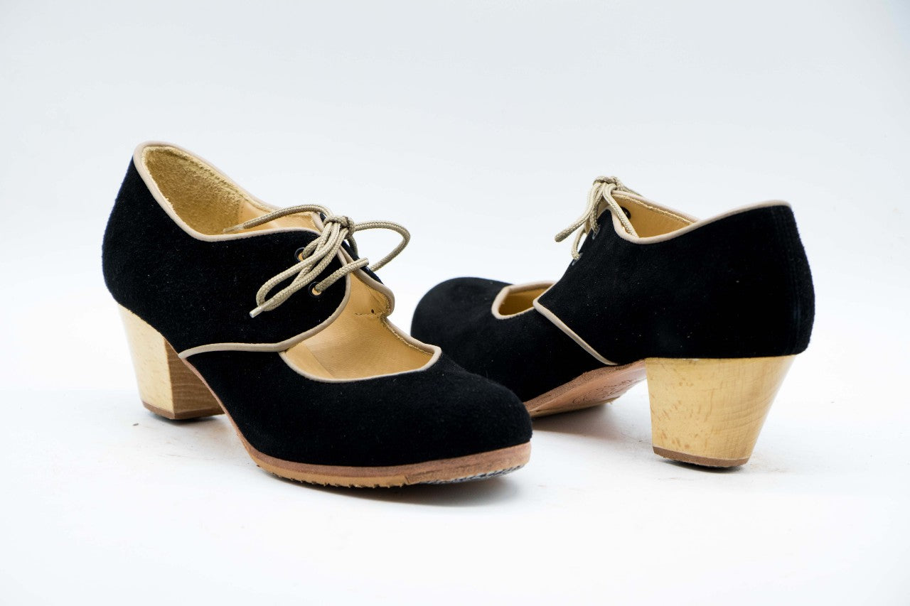 Zapatos de Flamenco profesional para mujer.  Únicos, hechos a mano por Antonio García.  Con cordones. Fabricado en Ante negro con ribete en piel beige. Con Tacón Cubano Barnizado de 5,5 cm. Con clavos. Suela profesional cosida con filis de microfibra para amortiguar el golpe. Duración y sonido excepcional.