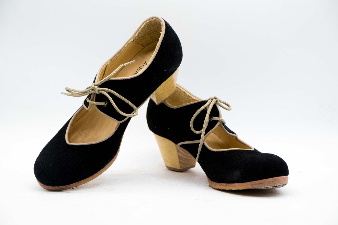 Zapatos de Flamenco profesional para mujer.  Únicos, hechos a mano por Antonio García.  Con cordones. Fabricado en Ante negro con ribete en piel beige. Con Tacón Cubano Barnizado de 5,5 cm. Con clavos. Suela profesional cosida con filis de microfibra para amortiguar el golpe. Duración y sonido excepcional.